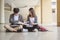 Two students are sitting on the floor reading books to education. Study for test preparation in University.