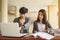 Two students are sitting at table reading books to education. Study for test preparation in University.