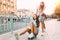 Two stylish excited girls have fun and skateboard in the Park in Sunny weather