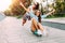 Two stylish excited girls have fun and skateboard in the Park in Sunny weather