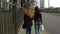 Two stylish girls walk along city roads