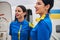 Two stylish modern Caucasian stewardesses standing outdoors