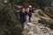 Two successful hiker woman friends enjoy the view on mountain peak. Happy backpackers in nature taking pictures with mobile phone