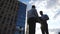 Two successful managers in formal wear meeting in urban and shaking hands. Young businessman passing a black briefcase