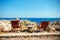 Two sun beds and stony table on rocky seashore in Greece Rhodes Kalithea