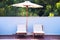 Two sun loungers under an umbrella on the outdoor patio