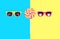 Two sunglasses and colorful lollipop caramel on stick over pink