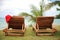 Two sunloungers with Santa hat standing on a beach