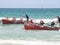 Two surf-boats and crew returning to shore racing as the ride the small waves in