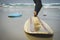 Two surfboards on the sand of the beach with waves at the bottom