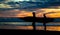 Two surfers on Piha Beach in sunset