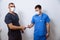 Two surgeons in sterile uniforms with medical instruments on white background at hospital