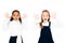 two surprised multicultural schoolgirls showing chalk stained hands isolated on white.