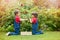 Two sweet boys, gathering red currants from their home garden