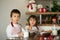 Two sweet children, boy brothers, preparing gingerbread cookies