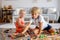 Two sweet children, siblings, playing with trains at home