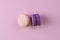 Two sweet french desserts of pastel pink and purple macaroons or macarons