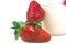 Two sweet ripe strawberries with yogurt cups near