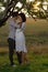 Two sweethearts kissing under tree at sunset