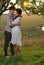 Two sweethearts kissing under tree at sunset