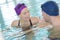 Two swimmers talking in pool