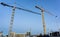 Two tall construction cranes on city redevelopment site for the new Farmers building