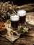 Two tankard beer with wheat and hops , basket of pretzels