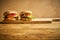 Two tasty burgers on wooden board and black background