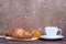 Two tasty classical croissant and coffee cappuccino on table