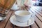 Two teacups and French press on the table, blurred woman behind. Pouring tea concept.