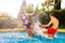 Two teen couples splash and play in water pool