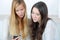 Two teen girls shocked watching message on their smartphone