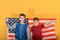 Two teenage brothers are standing against the backdrop of the American flag, young scouts are patriots