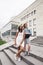 Two teenage diverse nations girls infront of university building smiling, having fun traveling europe, lifestyle people