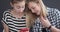 Two teenage girls discussing and using smartphone