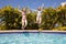 Two teenage girls jumping in a swimming pool