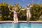 Two teenage girls jumping in a swimming pool