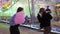 Two teenage girls playing paper rock scissors game outdoor in Valencia funfair at night