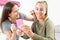 Two Teenage Girls Putting On Make Up In Bedroom