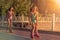 Two teenage girls, roller skates and dancing during sunset , park.