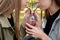 Two teenage girls sharing fruit cocktail in park on sunny day