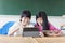Two teenage girls student watching the tablet in classroom