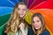 Two teenage girls under colorful umbrella