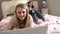Two Teenage Girls Using Digital Devices In Bedroom