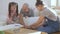 Two teenage sisters help their father put together a new shelves for the children`s room.