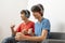 Two teenager boys listening to music with headphones in living room.