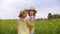 Two teenager girl in straw hat and summer dress posing on sunflower field. Beautiful girl friends looking back on