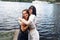 Two teenager girls sitting on a pier at the river bank having good time in summer. happy girl friends relaxing outdoor near lake.