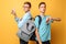 Two teenagers, guys show opposite emotions, friends show positive and negative gestures, on a yellow background