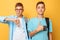 Two teenagers, guys show opposite emotions, friends show positive and negative gestures, on a yellow background